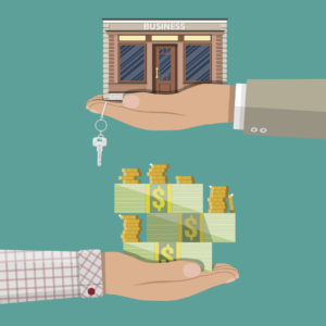Hand holding shop or commercial property with key.