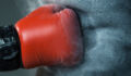 A boxing glove punches a punching bag