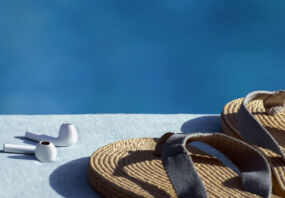 Headphones and sandals by the side of a pool