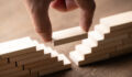 Is an acquired firm better off integrated or kept separate? A hand places a block in between a gap of stacked blocks