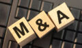 Image of blocks spelling out M&A, representing mergers and acquisitions.