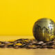 Gold globe with Asia showing laying on gold coins.
