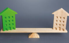 Image of two wood block buildings on a wooden scale.