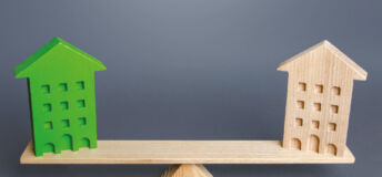 Image of two wood block buildings on a wooden scale.