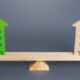 Image of two wood block buildings on a wooden scale.