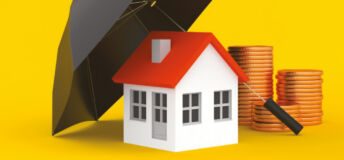 Image of a house under an umbrella next to coins.