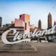 In Ohio the Cleveland script sign is placed in front of the cityscape with the Rock and Roll Hall of Fame building.