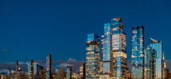 Wide view of Hudson Yards skyline and Vessel at night. Panoramic night shot of Manhattan west side with illuminated Vessel and Hudson Yards modern skyscrapers.