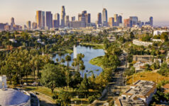 Aerial view of Echo Park Lake surrounded by neighbourhood with high rise office buildings in background, City Of Los Angeles, California, USA.
