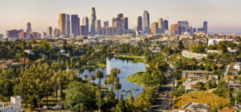 Aerial view of Echo Park Lake surrounded by neighbourhood with high rise office buildings in background, City Of Los Angeles, California, USA.