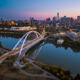 AIMCo names global real estate chief, ending year-long vacancy Aerial view of the Walterdale Bridge and downtown Edmonton skyline at dusk, with the North Saskatchewan River reflecting the warm city lights. The modern bridge and illuminated high-rises represent the urban growth and architectural design of Albertaโs capital city. This scenic image captures themes of transportation, engineering, tourism, and modern Canadian infrastructure.
