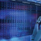 The new risks in data center investing Illustration of a robot posing as if it is thinking while looking at a series of computers.